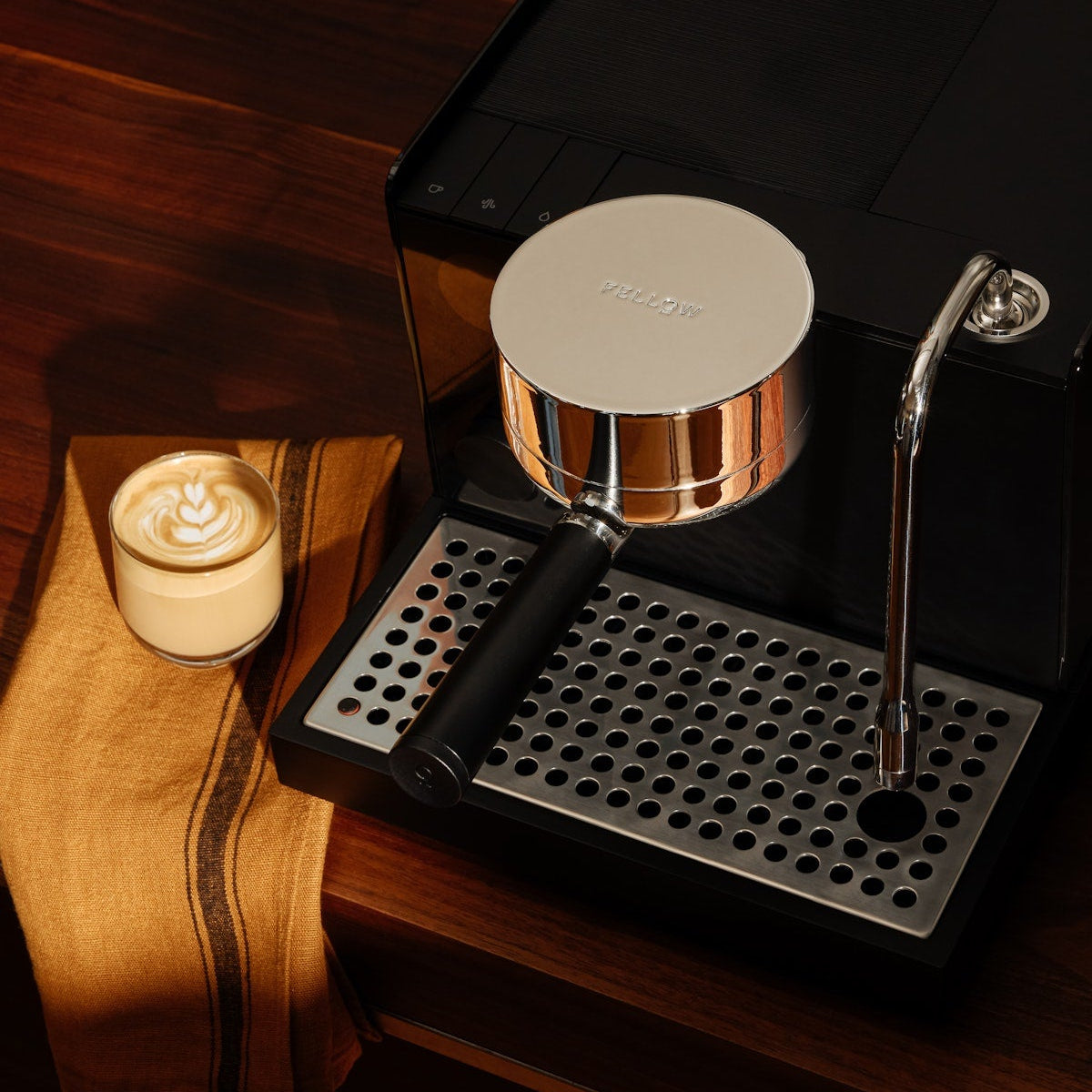 Espresso machine on a wooden surface with a candle in the background
